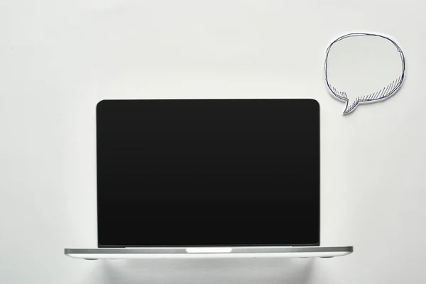 Laptop with blank screen on white background near empty speech bubble, cyberbullying concept — Stock Photo