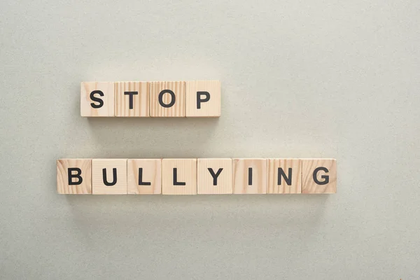 Vista dall'alto di blocchi di legno con stop bullismo lettering su sfondo grigio — Foto stock