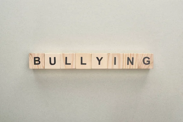 Vista superior de blocos de madeira com letras de bullying no fundo cinza — Fotografia de Stock