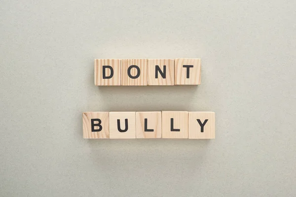 Top view of wooden blocks with dont bully lettering on grey background — Stock Photo