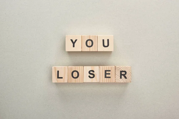 Top view of wooden blocks with you loser lettering on grey background, bullying concept — Stock Photo