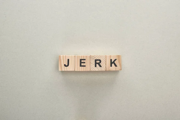 Top view of wooden blocks with jerk lettering on grey background, bullying concept — Stock Photo