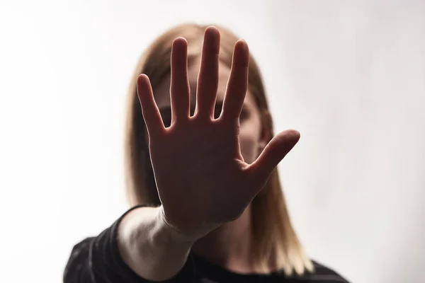 Selective focus of victim of bullying showing stop sign isolated on white — Stock Photo