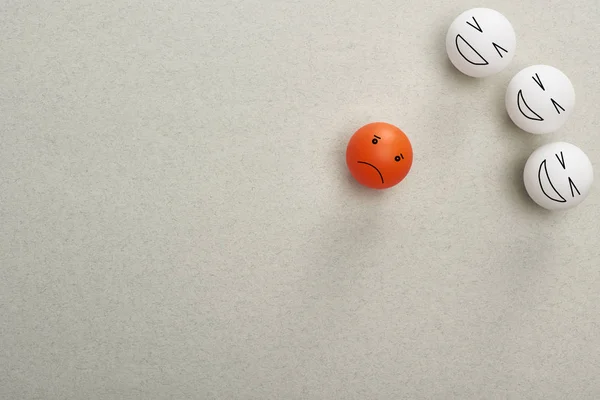 Top view of balls with cruel and sad face expressions symbolizing victim and abusers on grey background — Stock Photo