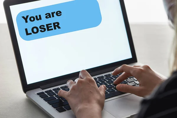 Vista cortada de menina digitando no teclado do laptop com você são mensagem perdedora na tela, conceito de cyberbullying — Fotografia de Stock