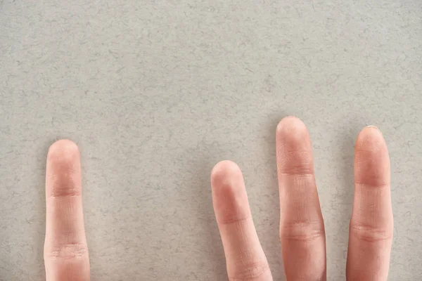 Vista ritagliata dell'uomo che mostra le dita che simboleggiano gli abusatori e la vittima su sfondo grigio — Foto stock