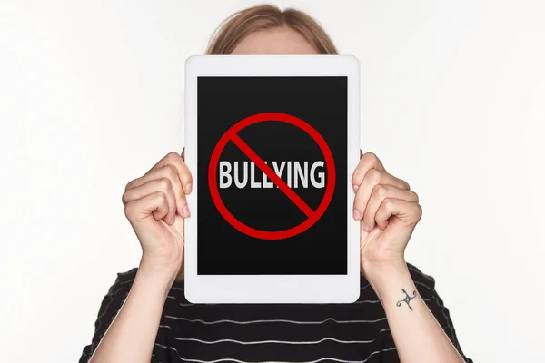 Vítima de cyberbullying mostrando tablet digital com stop bullying cantar na tela isolada em branco — Fotografia de Stock