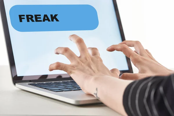 Cropped view of girl typing on laptop keyboard with fresk message on screen, cyberbullying concept — Stock Photo