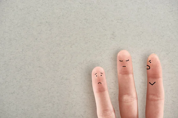 Partial view of man showing three fingers symbolizing aggressive abuser and sad victims on grey background — Stock Photo