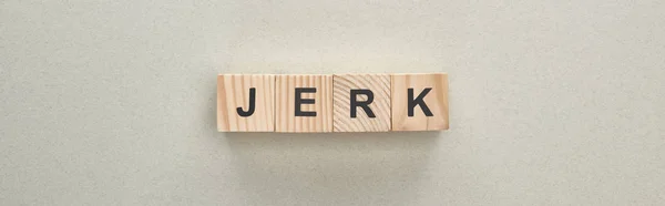 Panoramic shot of wooden blocks with jerk lettering on grey background, bullying concept — Stock Photo