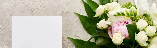 Panoramic shot of empty card near bouquet of flowers on textured surface — Stock Photo