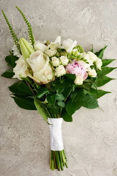 Vue de dessus du bouquet de mariage avec des roses et des fleurs d'eustomie sur la surface texturée — Photo de stock