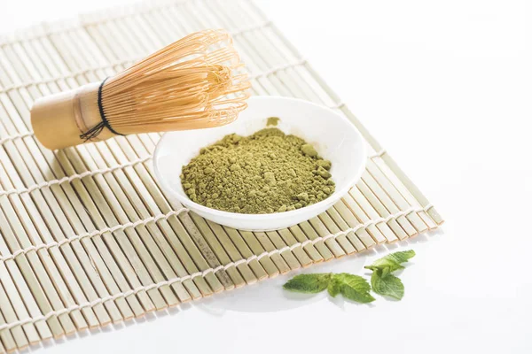 Poudre de thé vert matcha avec fouet sur tapis de bambou — Photo de stock