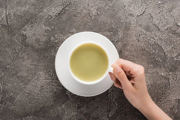 Ansicht von oben: Frau hält Tasse Matcha-Tee in der Hand — Stockfoto