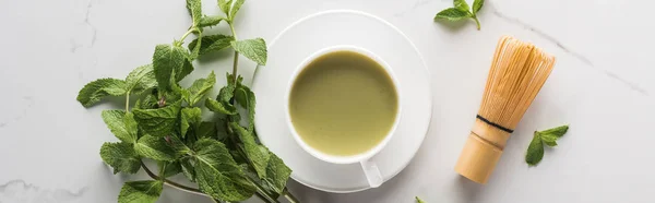 Vista dall'alto del tè matcha verde con menta e frusta sul tavolo bianco — Foto stock
