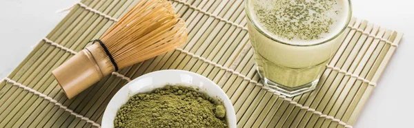 Grüner Matcha-Tee und Schneebesen auf Bambusmatte — Stockfoto