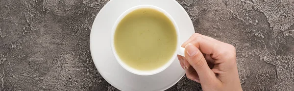 Vue du dessus de la femme tenant matcha matcha thé dans la tasse — Photo de stock