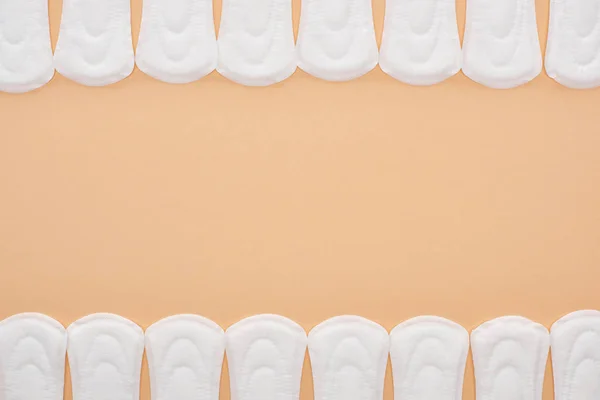 Frame of white cotton sanitary towels isolated on beige with copy space — Stock Photo