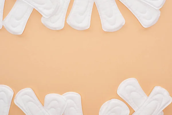 Top view of scattered white cotton sanitary towels isolated on beige — Stock Photo