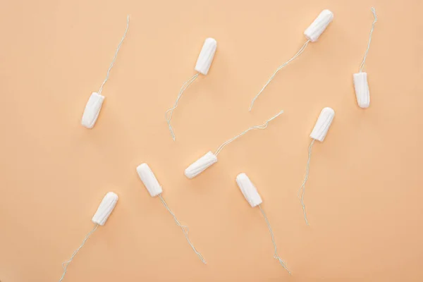 Top view of white cotton tampons scattered isolated on beige — Stock Photo