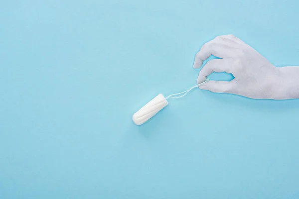 Vue du dessus de la main en papier blanc et tampon en coton sur fond bleu — Photo de stock