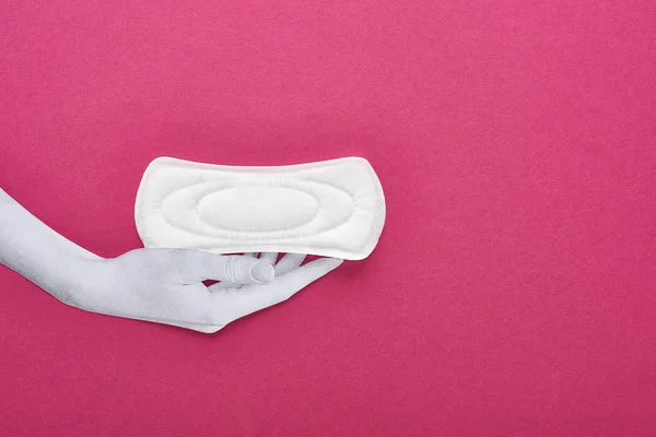 Vista superior de papel cortado mano blanca y servilleta sanitaria blanca sobre fondo púrpura - foto de stock