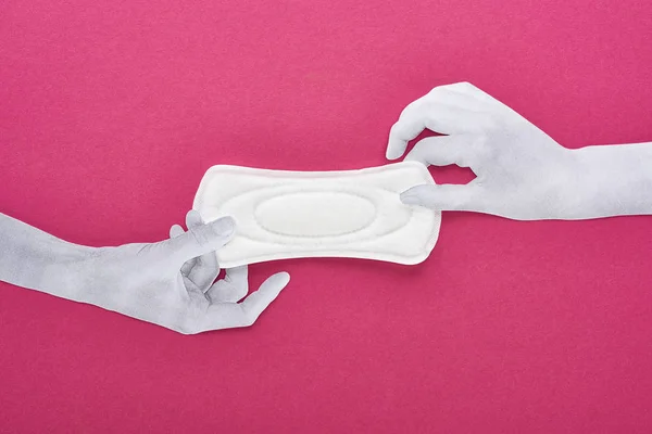 Top view of paper cut hands and white sanitary napkin on purple background — Stock Photo
