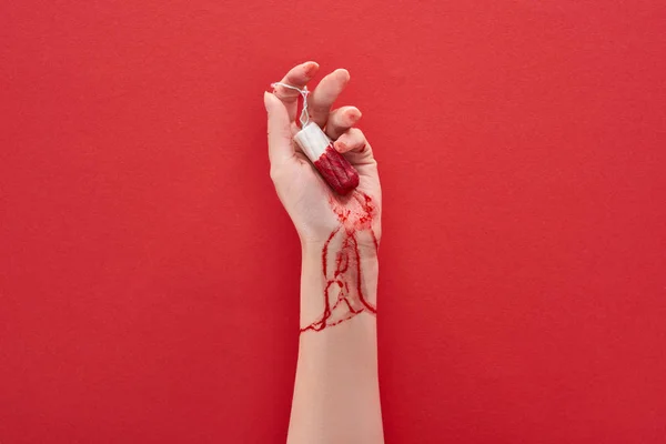 Partial view of woman holding tampon with blood on red background — Stock Photo