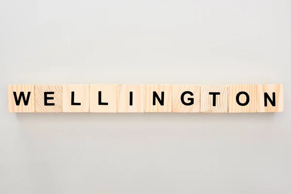 Top view of wooden blocks with Wellington lettering on white background — Stock Photo