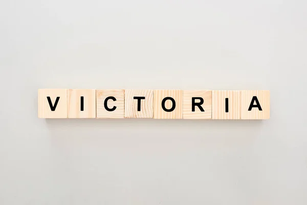 Vista dall'alto di blocchi di legno con scritte Victoria su sfondo bianco — Stock Photo