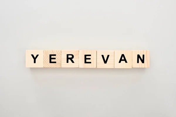 Vista superior de blocos de madeira com letras Yerevan no fundo branco — Fotografia de Stock