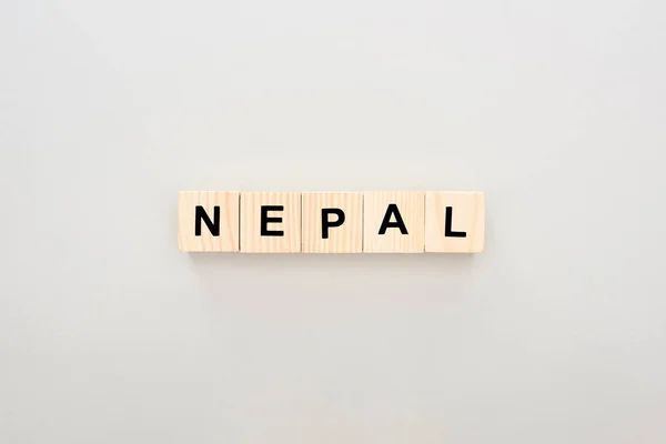 Vista superior de blocos de madeira com letras Nepal sobre fundo branco — Fotografia de Stock