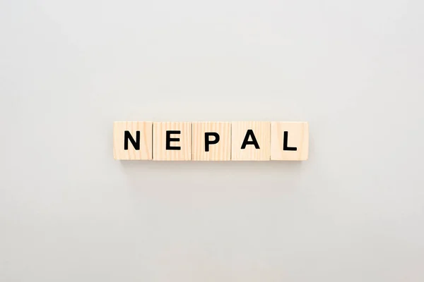 Vista superior de bloques de madera con letras de Nepal sobre fondo blanco - foto de stock