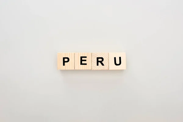 Vista superior de blocos de madeira com letras Peru no fundo branco — Fotografia de Stock