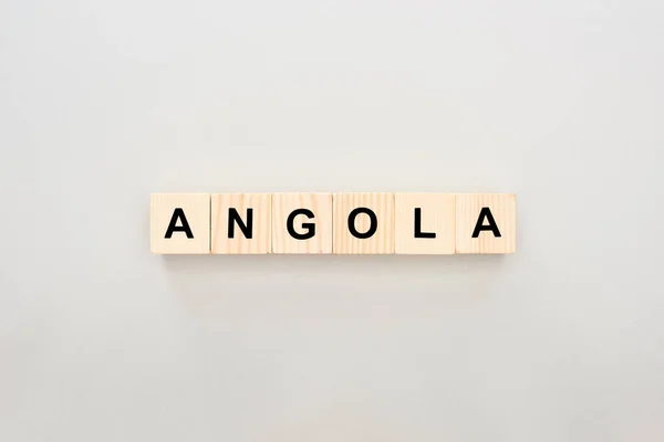 Top view of wooden blocks with Angola lettering on white background — Stock Photo