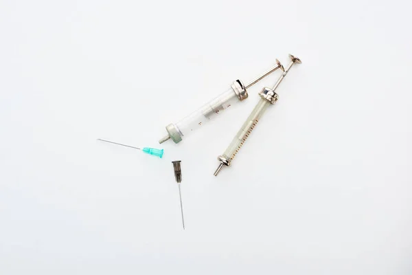 Top view of aged syringes with needles on white background with copy space — Stock Photo