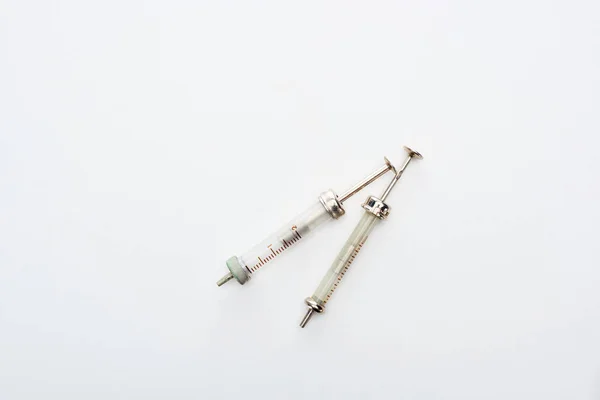 Vista superior de seringas envelhecidas sobre fundo branco com espaço de cópia — Fotografia de Stock
