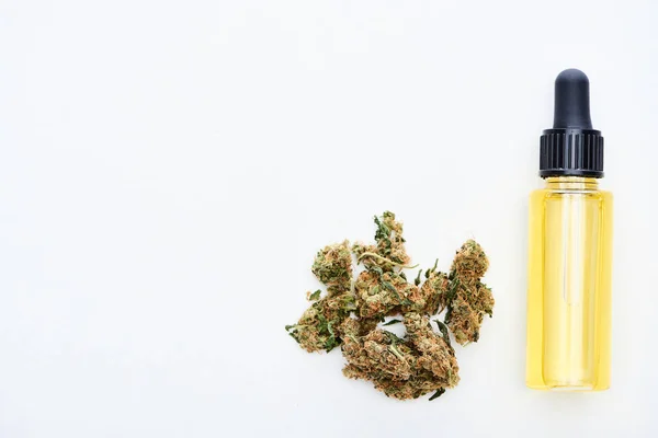 Ansicht von oben auf cbd Öl und Marihuana Knospen isoliert auf weiß — Stockfoto