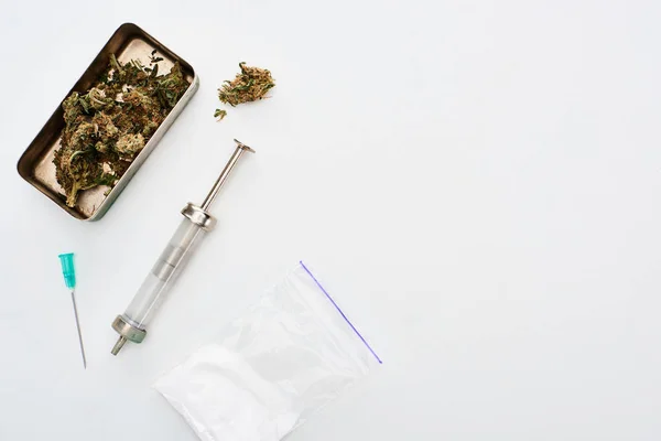 Top view of marijuana buds, heroin and syringe on white background — Stock Photo