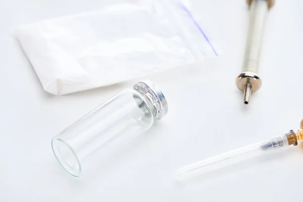 Close up view of ampoule, syringes and heroin on white background — Stock Photo