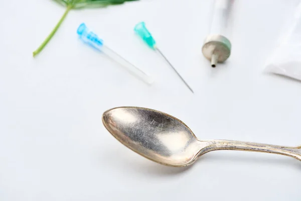 Close up view of spoon, syringe and needles on white background — Stock Photo