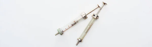 Top view of aged syringes on white background with copy space, panoramic shot — Stock Photo