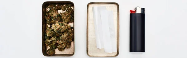 Pose plate avec boîte en métal avec des bourgeons de marijuana et du papier à rouler près de briquet, vue panoramique — Photo de stock