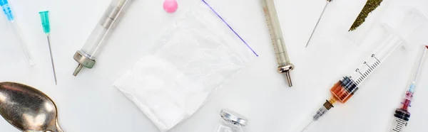 Vista superior de maconha, seringas com heroína, lsd e colher no fundo branco, tiro panorâmico — Fotografia de Stock