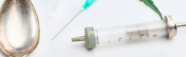 Close up view of spoon, syringe and needle on white background, panoramic shot — Stock Photo