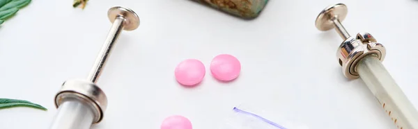 Nahaufnahme von Spritzen in der Nähe von rosa Ecstasy und Heroin auf weißem Hintergrund, Panoramaaufnahme — Stockfoto