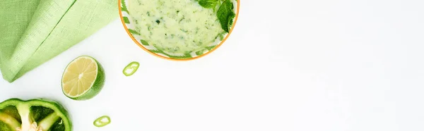 Top view of delicious creamy green vegetable soup served isolated on white with ingredients, panoramic shot — Stock Photo