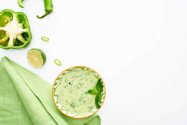 Top view of delicious creamy green vegetable soup served with napkin isolated on white — Stock Photo