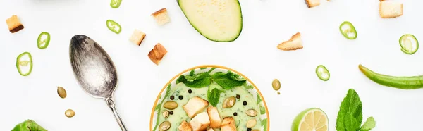 Plan panoramique de délicieuse soupe de légumes vert crémeux avec cuillère en argent isolé sur blanc — Photo de stock