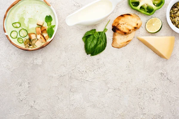 Top view of tasty green creamy soup with croutons on textured grey background with copy space — Stock Photo